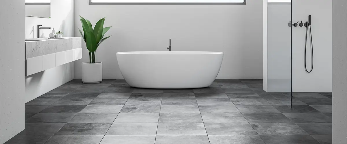 Bathroom flooring with large black tile and a freestanding tub