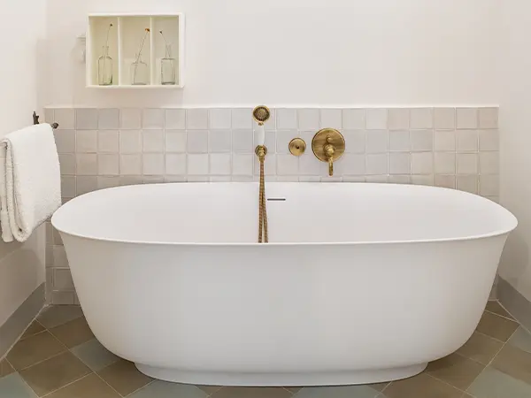 A freestanding tub with golden fixtures