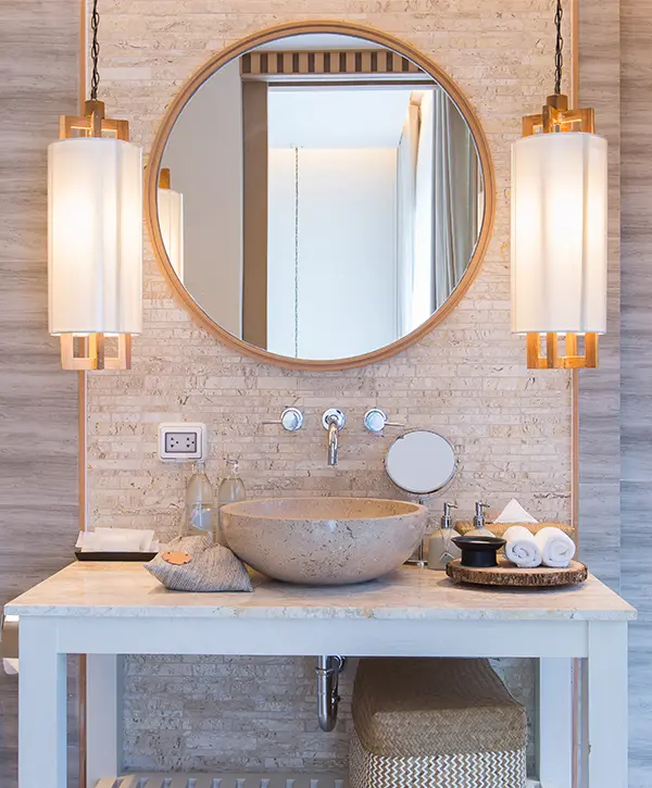 Round mirror with beautiful lighting in a bathroom remodel