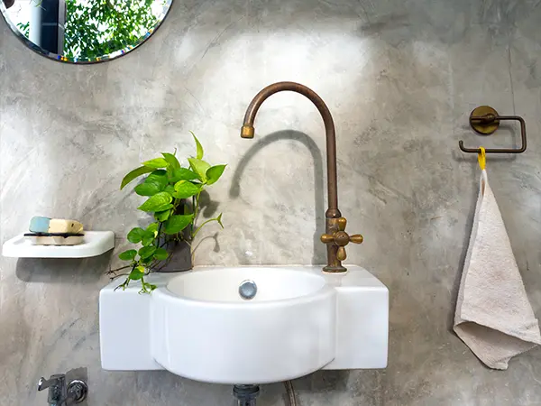 Sink attached to wall with gold faucet