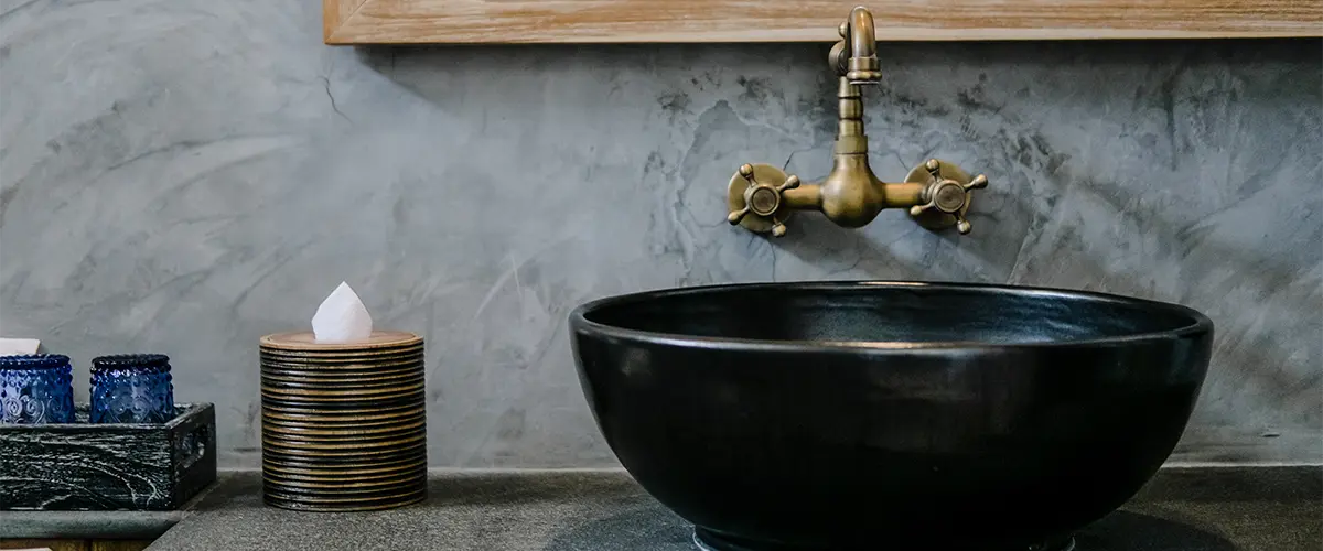A beautiful black sink with golden faucet