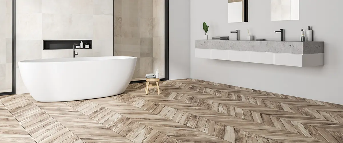 Herringbone wood floor in a bathroom with freestanding tub and modern vanity