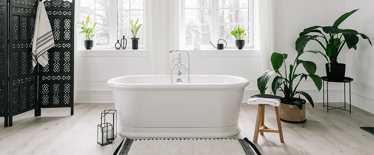 A beautiful bathroom with plants and a freestanding tub in the center of the room