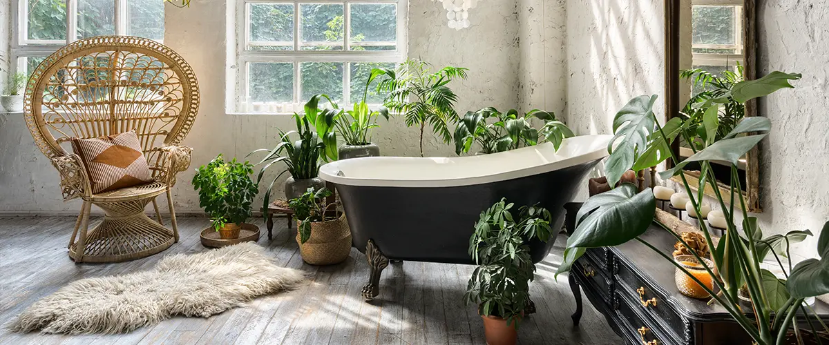 A freestanding tub with a lot of plants and wood flooring
