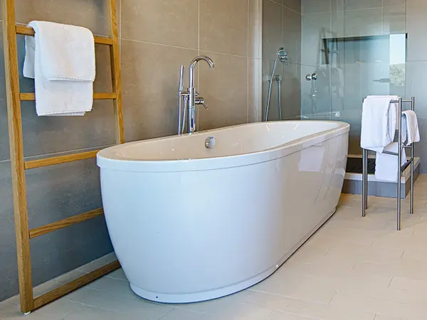 Freestanding tub in a modern bath with large tile flooring