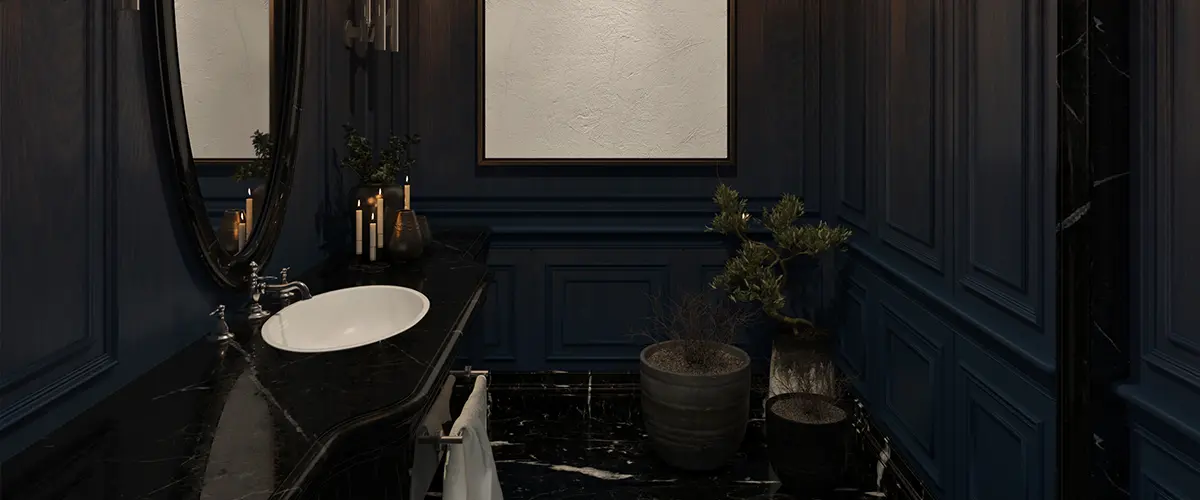 A powder room with black countertop and dark blue walls