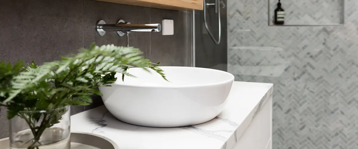 A quartz countertop with a round vessel sink