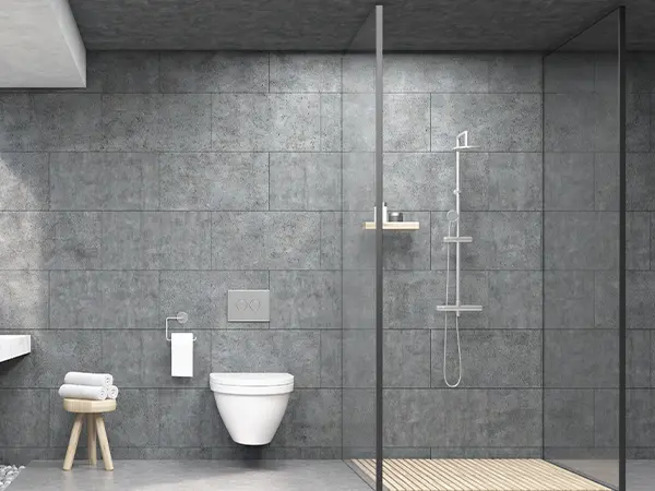 A glass walk-in shower with tile flooring and surround and a toilet