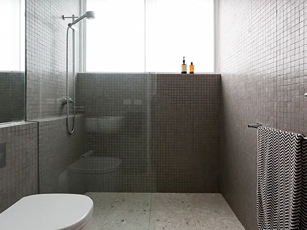 A glass walk-in shower with tile surround