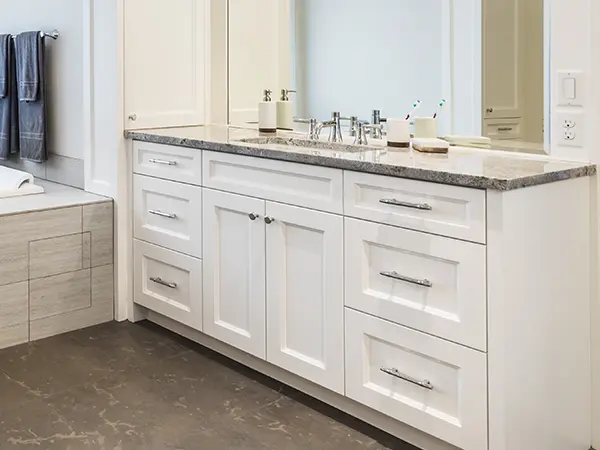 White vanity with silver hardware and quartz top
