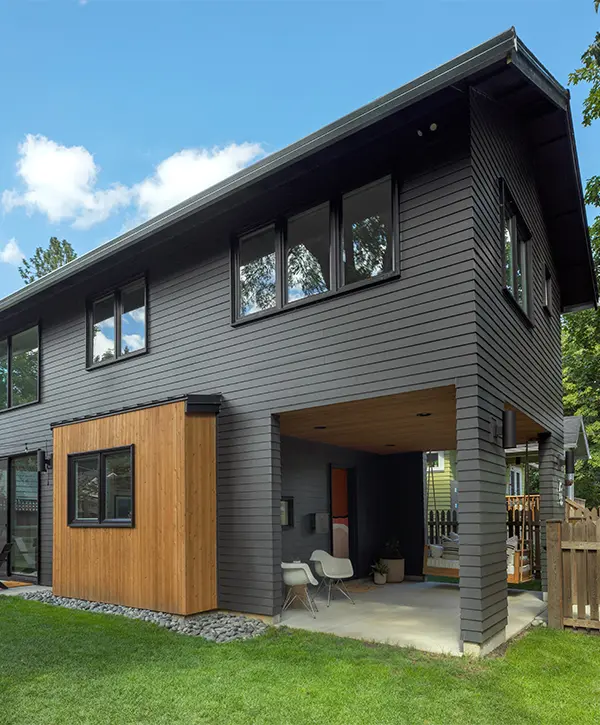 A small, black home addition with a wood bump-out