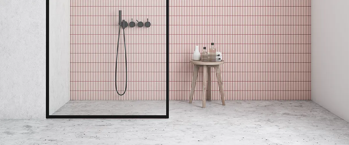 An epoxy flooring with pink shower tile surround
