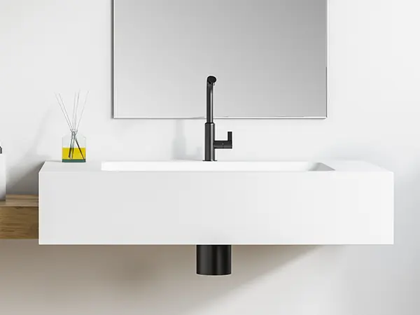 A simple wall mounted sink with a black water fixture